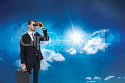 Composite image of businessman holding a briefcase while using b