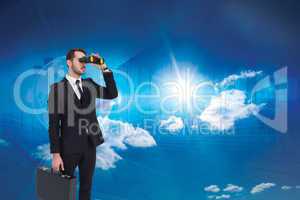 Composite image of businessman holding a briefcase while using b