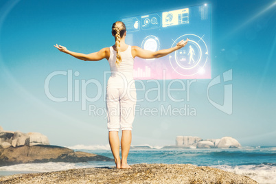 Composite image of blonde woman standing on beach on rock with a