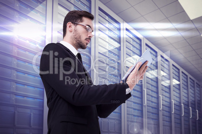 Composite image of businessman with glasses using his tablet