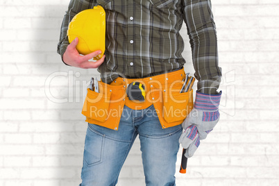 Composite image of manual worker wearing tool belt while holding