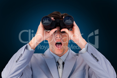 Composite image of suprised businessman looking through binocula