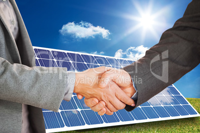 Composite image of two people having a handshake in an office