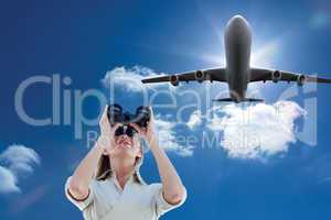 Composite image of businesswoman looking through binoculars