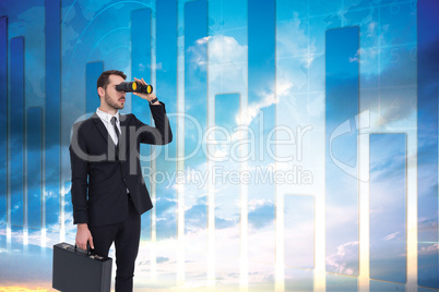 Composite image of businessman holding a briefcase while using b