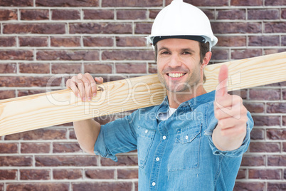 Composite image of confident carpenter carrying wooden plank