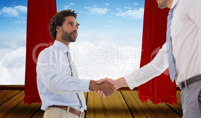 Composite image of young businessmen shaking hands in office