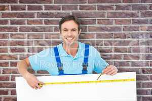 Composite image of happy carpenter measuring blank bill board