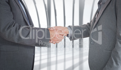 Composite image of close up on two businesspeople shaking hands