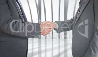 Composite image of close up on two businesspeople shaking hands