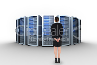 Composite image of young businesswoman standing with hands behin