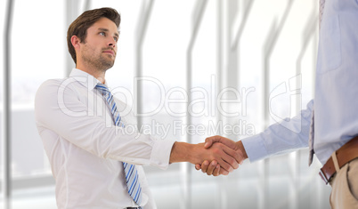 Composite image of two businessmen shaking hands in office