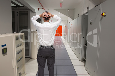 Composite image of businessman standing back to camera hands on