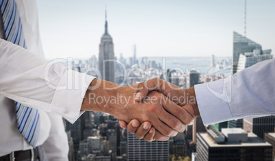 Composite image of close-up shot of a handshake in office