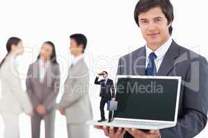 Composite image of businessman looking through binoculars holdin