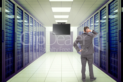 Composite image of young businessman standing back to camera scr