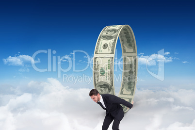 Composite image of businessman carrying something heavy with his