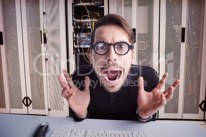 Composite image of worried businessman with glasses using comput