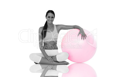 Composite image of smiling fit young woman sitting with fitness