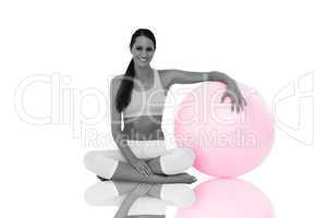 Composite image of smiling fit young woman sitting with fitness