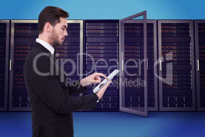 Composite image of concentrated businessman touching his tablet