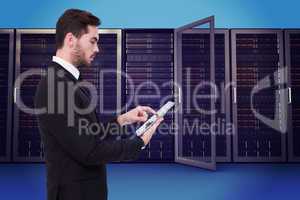 Composite image of concentrated businessman touching his tablet