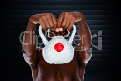 Composite image of shirtless fit young man lifting kettle bell