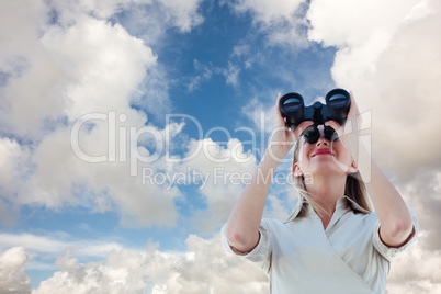 Composite image of businesswoman looking through binoculars