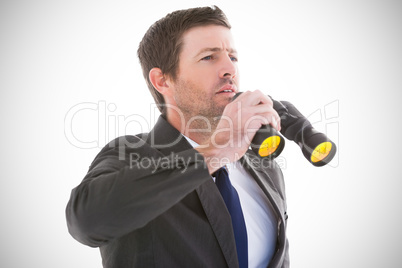 Composite image of focused handsome businessman holding binocula