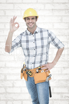 Composite image of handyman gesturing ok sign