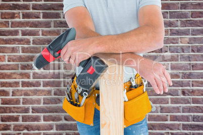 Composite image of midsection of male carpenter with power drill