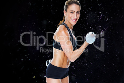 Composite image of female bodybuilder working out with large dum