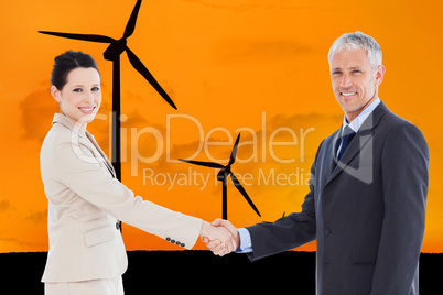 Composite image of smiling business people shaking hands while l