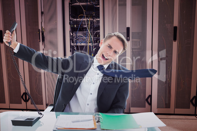 Composite image of businessman shouting as he holds out phone