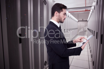 Composite image of concentrated businessman touching his tablet