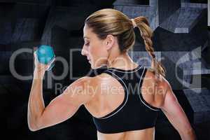 Composite image of female bodybuilder holding a dumbbell