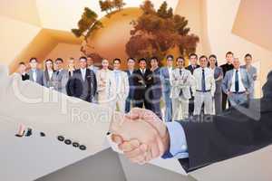 Composite image of smiling business people shaking hands while l