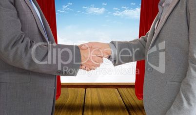 Composite image of close up on two businesspeople shaking hands