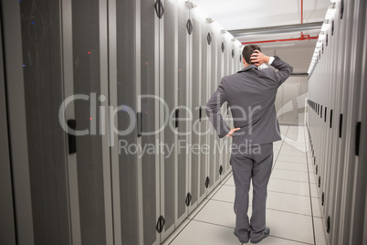 Composite image of young businessman standing back to camera scr