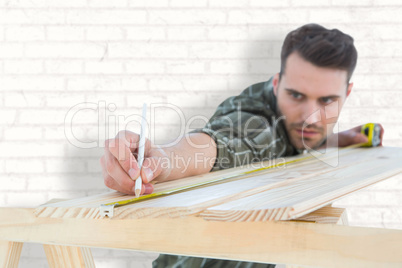Composite image of worker marking on wooden plank