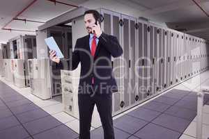 Composite image of businessman talking on phone holding tablet p