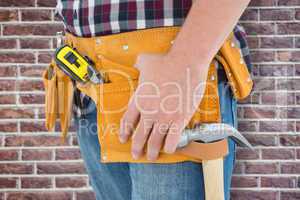 Composite image of close-up of male repairman wearing tool belt