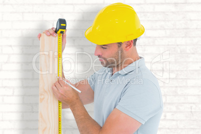 Composite image of carpenter using measure tape to mark on woode