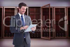 Composite image of businessman using his tablet pc