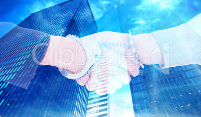 Composite image of business people in handcuffs shaking hands