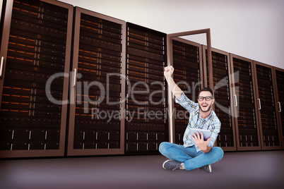 Composite image of handsome hipster using tablet pc and cheering