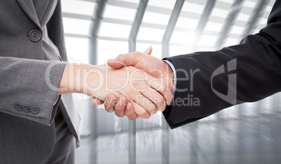 Composite image of close up of two businesspeople shaking their