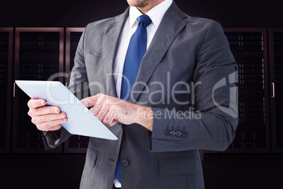Composite image of businessman using his tablet pc Composite image of businessman using his tablet pc
