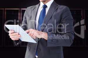 Composite image of businessman using his tablet pc