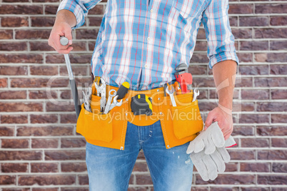 Composite image of midsection of handyman holding hammer and glo